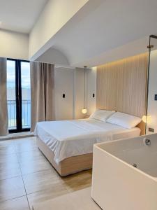 a bedroom with a large bed and a bath tub at Hotel Balcones in La Hormiga