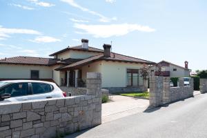 a white car parked in front of a house at I&R Apartma in Hrpelje