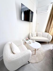 a white living room with a couch and a table at Cocon doré au coeur de Limay in Limay