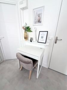 a white desk with a chair next to a door at Cocon doré au coeur de Limay in Limay