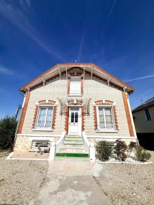 a large brick building with a white door at Cocon doré au coeur de Limay in Limay