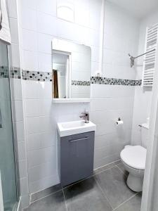 a bathroom with a toilet and a sink and a mirror at Cocon doré au coeur de Limay in Limay