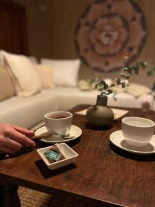 a coffee table with two cups and plates on it at Posada La Tregua in El Bolsón