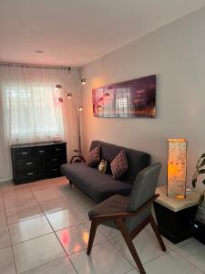a living room with a couch and a chair at Habitaciones cómodas en Coto Galeana Guadalajara in Guadalajara