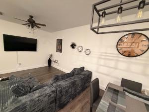 a living room with a couch and a clock on the wall at Casa Lux in Florida City