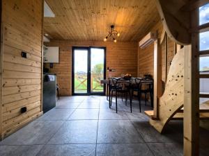 a kitchen and dining room with wooden walls and a table at Chatki wisla houses in Wisła