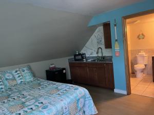 a bedroom with a bed and a bathroom with a sink at Pine View Lodge Old Orchard Beach in Old Orchard Beach