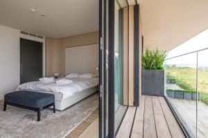 a bedroom with a bed and a sliding glass door at Residence DeBlanke Top - 1D - Cadzand in Cadzand-Bad