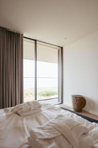 a bedroom with a bed and a large window at Residence DeBlanke Top - 1D - Cadzand in Cadzand-Bad +34 photos