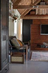 a living room with a couch and a tv at Gastenverblijf Begheynhof - your perfect escape in Biervliet