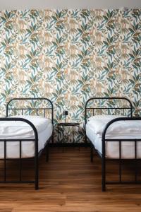 three beds in a room with a floral wallpaper at Penzión ZAYDA in Výrava