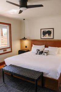 a bedroom with a large bed with a ceiling fan at The Stranger Lodge - Pet Friendly in Sisters