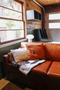a couch with pillows on it in a room at The Stranger Lodge - Pet Friendly in Sisters