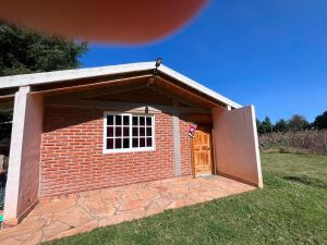 a small brick dog house with a door at El rinconcito in Omitlán de Juárez
