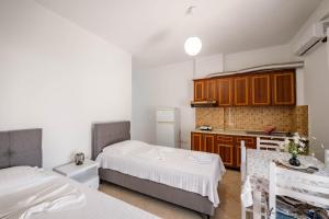 a small room with two beds and a kitchen at Nefeli apartments in Borsh +70 photos