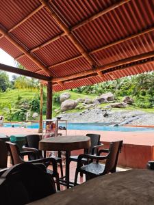 a patio with tables and chairs and a pool at Finca Agroturística La pradera in Acacías