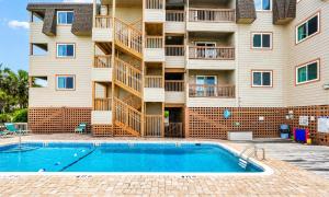 a building with a swimming pool in front of a building at Ocean Forest Colony in Myrtle Beach