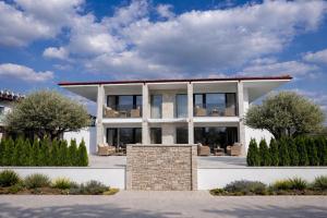 a large white house with trees in front of it at Amore Fanari in Fanari
