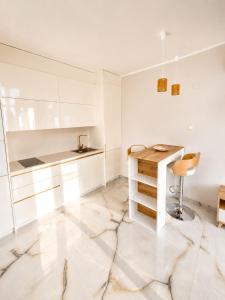 a kitchen with white cabinets and a table and a stool at Amore Fanari in Fanari +7 photos