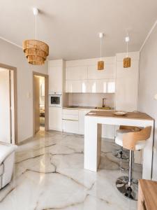 a kitchen with white cabinets and a marble floor at Amore Fanari in Fanari