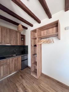 a kitchen with wooden cabinets and a sink at Anogeio in Afitos