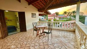 a patio with a table and chairs on a balcony at Suíte privativa - Centro Guararema in Guararema +5 photos
