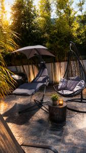 a patio with two chairs and a swing and an umbrella at Villa Aronora in Rabat
