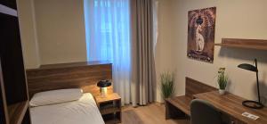 a bedroom with a bed and a desk and a window at Drei Schweizer Hotel in Neuwied