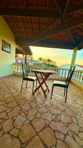 two chairs and a picnic table on a patio at Suíte privativa - Centro Guararema in Guararema
