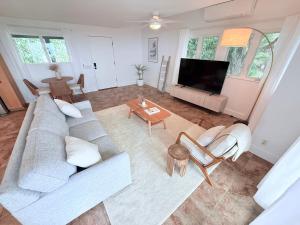 a living room with a couch and a tv at Kona Kai Ocean View Suite in Kailua-Kona