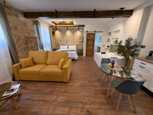 a living room with a yellow couch and a bedroom at La Flor in El Molar +46 photos