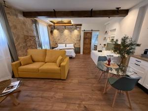 a living room with a yellow couch and a bedroom at La Flor in El Molar