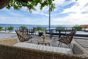 a patio with chairs and tables and a view of the water at Apartments Marin in Podstrana