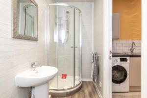 a bathroom with a shower with a sink and a washing machine at Central Apartment Darlington in Darlington +114 photos