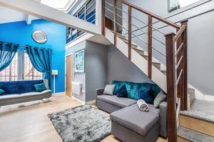 a living room with blue walls and a staircase at Central Apartment Darlington in Darlington