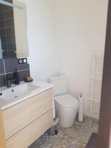 a bathroom with a white toilet and a sink at Maison d'hôtes en grès rouge in Lanteuil +8 photos