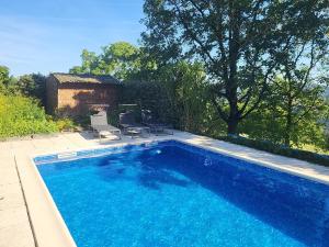 a large swimming pool with two chairs next to it at Anaky rider nomade in Curvalle