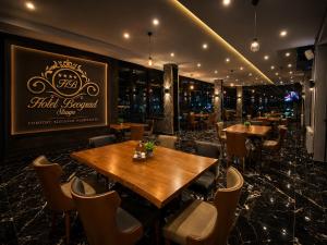 a restaurant with wooden tables and chairs and a sign at Hotel Beograd Struga in Struga