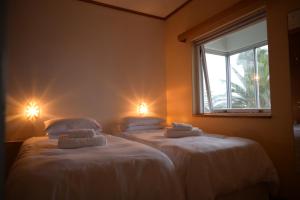 two beds in a room with lights on the wall at Sleep to the Sound of Waves - Full Private Apartment in Swakopmund