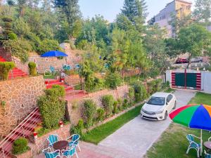 a car parked in a parking lot with an umbrella at BHURBAN MOUNTAIN VIEW APARTMENTs in Murree