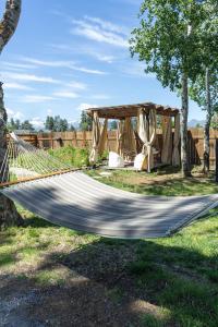 a hammock in a field with a tent at The Stranger Lodge - Pet Friendly in Sisters