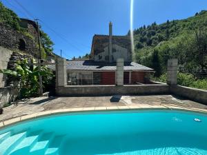 a swimming pool in front of a house at Le mas des Anglades in Saint-André-de-Valborgne
