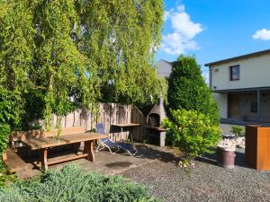 a backyard with a wooden picnic table and a tree at Am Flutgraben in Adorf