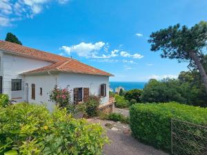 a white house with a view of the ocean at Villa Vue Panoramique sur les îles de Lérins in Saint-Raphaël