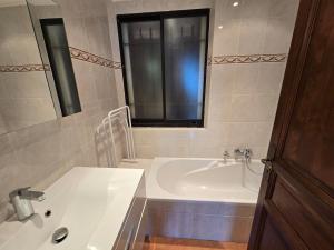 a bathroom with a tub and a sink and a window at Villa Vue Panoramique sur les îles de Lérins in Saint-Raphaël +32 photos