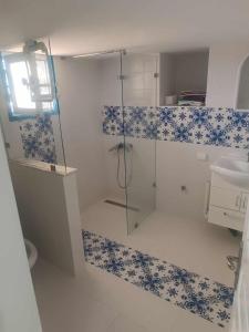 a bathroom with a glass shower and a sink at Authentic, quiet and spacious house in El Guecheïne