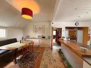 a kitchen and living room with a table and chairs at Glenan Lodge Self Catering in Tomatin