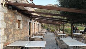 a row of tables and chairs on a patio at Aspalathos guest rooms in Vathia