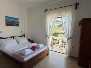 a bedroom with a bed with towels and a balcony at Zourpos Studios in Kalyves