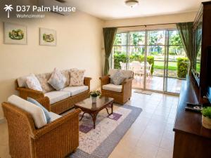 a living room with a couch and chairs and a tv at Oceanside Place in Rayong